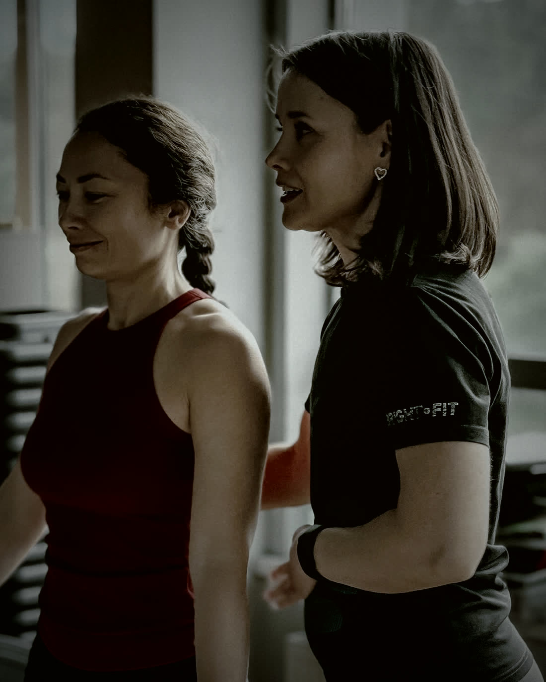 Une coach et sa cliente en pleine séance, dans une salle de sport.